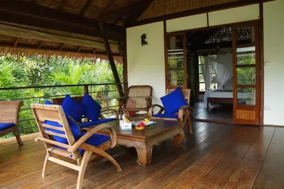 a living room with blue chairs and a table at Koyao Bay Pavilions - Beach Resort and Pool Villas in Ko Yao Noi