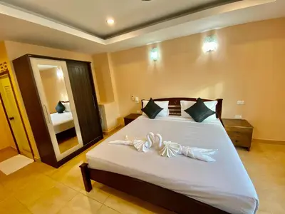 a bedroom with a large white bed with a large mirror at Star Guesthouse in Patong Beach