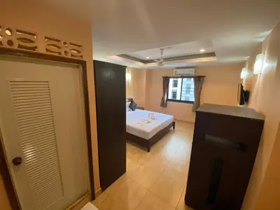 a bedroom with a bed and a door to a bathroom at Star Guesthouse in Patong Beach