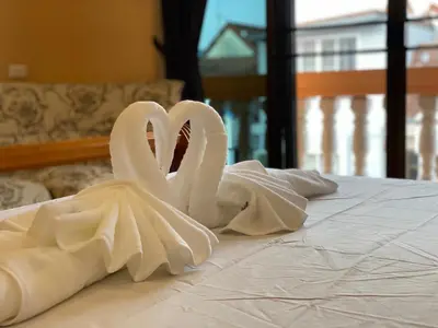 two white swans sitting on top of a bed at Star Guesthouse in Patong Beach