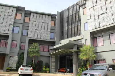 a white car parked in front of a building at Dinar Lodge in Bang Tao Beach