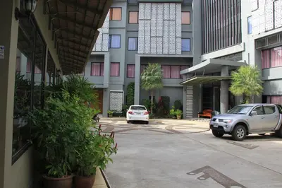 a car parked in a parking lot in front of a building at Dinar Lodge in Bang Tao Beach