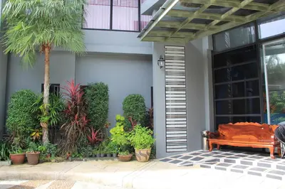 a bed sitting outside of a house with plants at Dinar Lodge in Bang Tao Beach