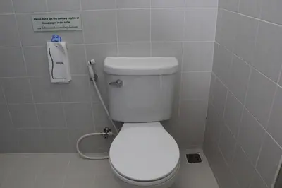 a bathroom with a white toilet in a stall at Dinar Lodge in Bang Tao Beach