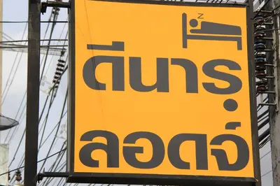 a yellow sign for a gas station at Dinar Lodge in Bang Tao Beach