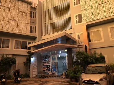 a building with a entrance with a car parked in front at Dinar Lodge in Bang Tao Beach
