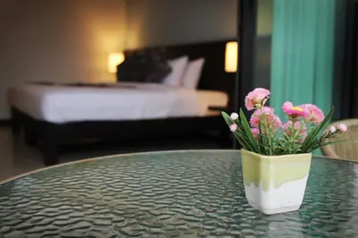 a vase of flowers sitting on a table in a hotel room at Simplitel in Karon Beach