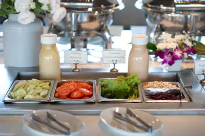 a buffet with plates of food and bottles of milk at Simplitel in Karon Beach