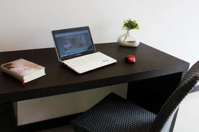a laptop computer sitting on top of a black desk at Simplitel in Karon Beach