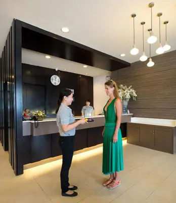 a man and a woman standing in a kitchen at Simplitel in Karon Beach