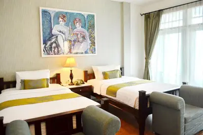 a hotel room with two beds and a painting on the wall at Casa Blanca Boutique Hotel - SHA Plus in Phuket Town