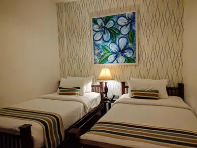 two beds in a room with a painting on the wall at Casa Blanca Boutique Hotel - SHA Plus in Phuket Town