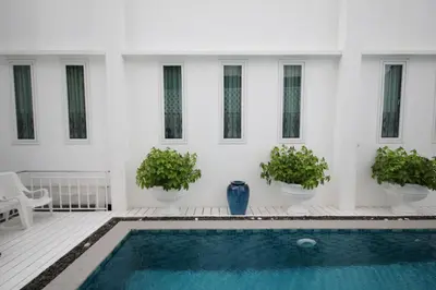 a white house with a swimming pool and potted plants at Casa Blanca Boutique Hotel - SHA Plus in Phuket Town