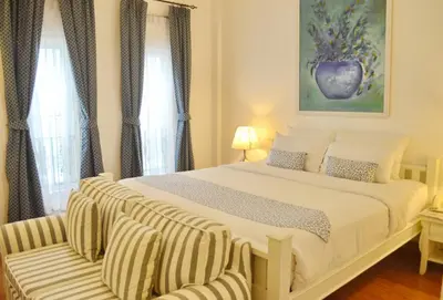 a bedroom with a large white bed with a chair at Casa Blanca Boutique Hotel - SHA Plus in Phuket Town