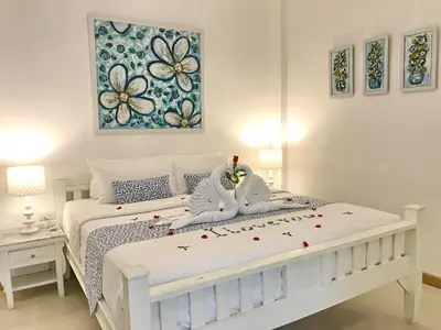 a bedroom with a white bed with flowers on it at Casa Blanca Boutique Hotel - SHA Plus in Phuket Town