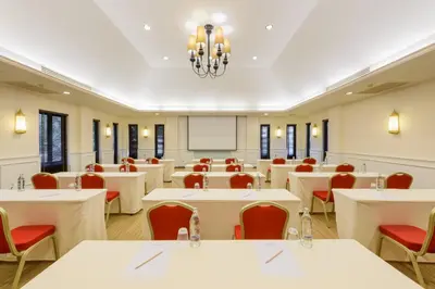 a conference room with white tables and red chairs at Centara Anda Dhevi Resort & Spa Krabi in Ao Nang Beach