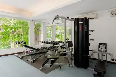 a gym with treadmills and machines in a room with a window at Centara Anda Dhevi Resort & Spa Krabi in Ao Nang Beach