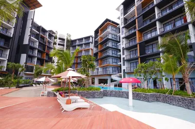 a patio with umbrellas and benches and buildings at Sea Seeker Krabi Resort in Ao Nang Beach