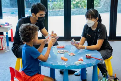 two adults and a child playing with legos at Sea Seeker Krabi Resort in Ao Nang Beach