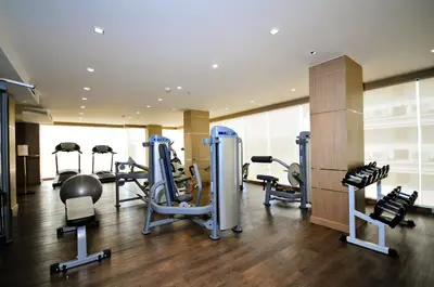 a gym with several tread machines in a room at ASHLEE Plaza Patong Hotel & Spa in Patong Beach