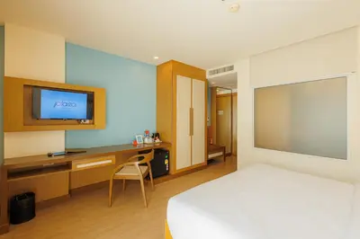 a bedroom with a bed and a desk and a television at ASHLEE Plaza Patong Hotel & Spa in Patong Beach