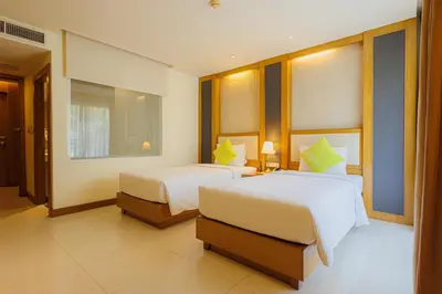a bedroom with two beds and a window at ASHLEE Plaza Patong Hotel & Spa in Patong Beach