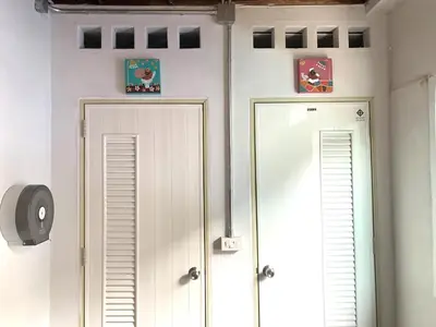 a hallway with two white doors and a mirror at Sleep Sheep Phuket Hostel SHA in Phuket Town