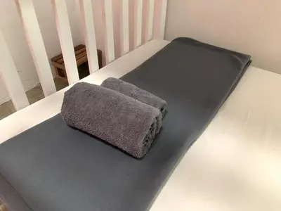 a grey pillow sitting on the bottom of a bed at Sleep Sheep Phuket Hostel SHA in Phuket Town