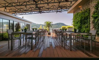 a patio with tables and chairs on a balcony at Gu Hotel Patong in Patong Beach