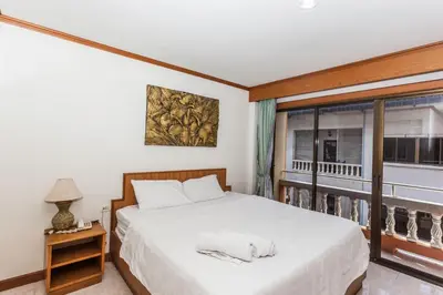 a bedroom with a bed and a balcony at Andaman Sea Patong in Patong Beach