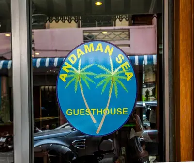 a sign on a glass door with a palm tree at Andaman Sea Patong in Patong Beach