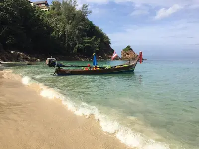a boat in the water on a beach at Супер апартаменты Найтон Naithon in Nai Thon Beach