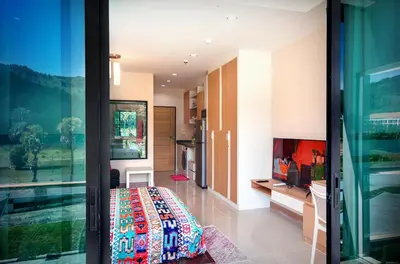 a room with a bed and a glass door at Супер апартаменты Найтон Naithon in Nai Thon Beach