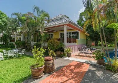 a yellow house with a patio and a pool at Lemon House in Patong Beach