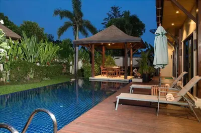 a swimming pool with chairs and a gazebo at VILLA Atarata Private Pool Nai Harn Beach in Rawai Beach