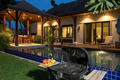 a barbecue grill sitting next to a swimming pool at VILLA Atarata Private Pool Nai Harn Beach in Rawai Beach