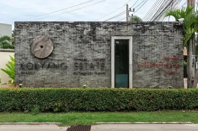 a brick building with a clock on the side of it at VILLA Atarata Private Pool Nai Harn Beach in Rawai Beach