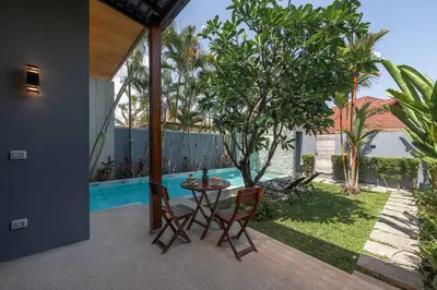 a patio with a table and chairs next to a pool at VILLA AWA Private Pool Naiharn beach in Rawai Beach