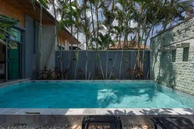 a swimming pool with two chairs in front of a house at VILLA AWA Private Pool Naiharn beach in Rawai Beach