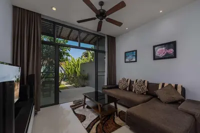 a living room with a couch and a ceiling fan at VILLA AWA Private Pool Naiharn beach in Rawai Beach