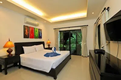 a bedroom with a bed and a flat screen tv at VILLA Emauha Pool Thaimond Residence Naiharn in Rawai Beach