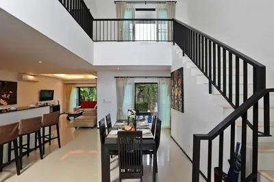 a living room with a staircase and a dining room at VILLA Emiemi Pool Thaimond Residence Naiharn in Rawai Beach