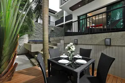 a black table and chairs on a patio with plants at VILLA Emiemi Pool Thaimond Residence Naiharn in Rawai Beach