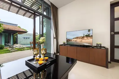 a living room with a tv and wine glasses on a table at Villa Hahana Private Pool Near Nai Harn Beach in Rawai Beach