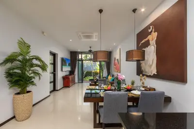 a living room with a table and a painting on the wall at VILLA Iotama Private Pool Nai Harn Beach in Rawai Beach