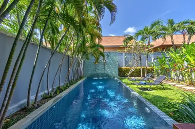 a swimming pool in the backyard of a villa with palm trees at VILLA Iotama Private Pool Nai Harn Beach in Rawai Beach