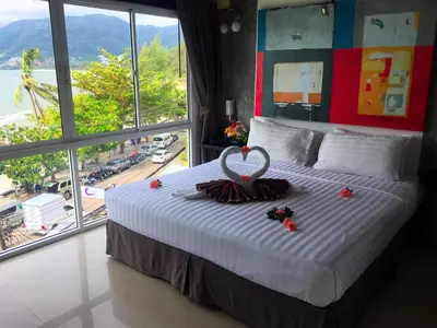 a hotel room with a bed with a wedding ring on it at The Front Hotel and Apartments in Patong Beach