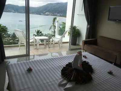 a bedroom with a bed with a view of the ocean at The Front Hotel and Apartments in Patong Beach