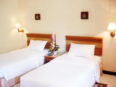 two beds in a hotel room with white sheets at Sunset Mansion in Patong Beach