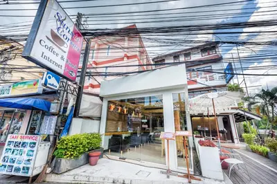 a store on the side of a street with power lines at Sunset Mansion in Patong Beach